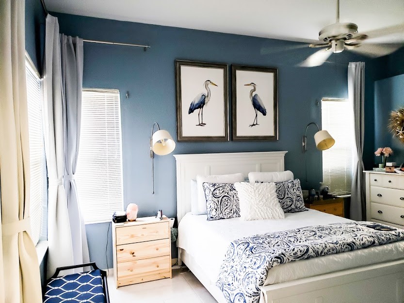 blue bedroom with large art over the white bed