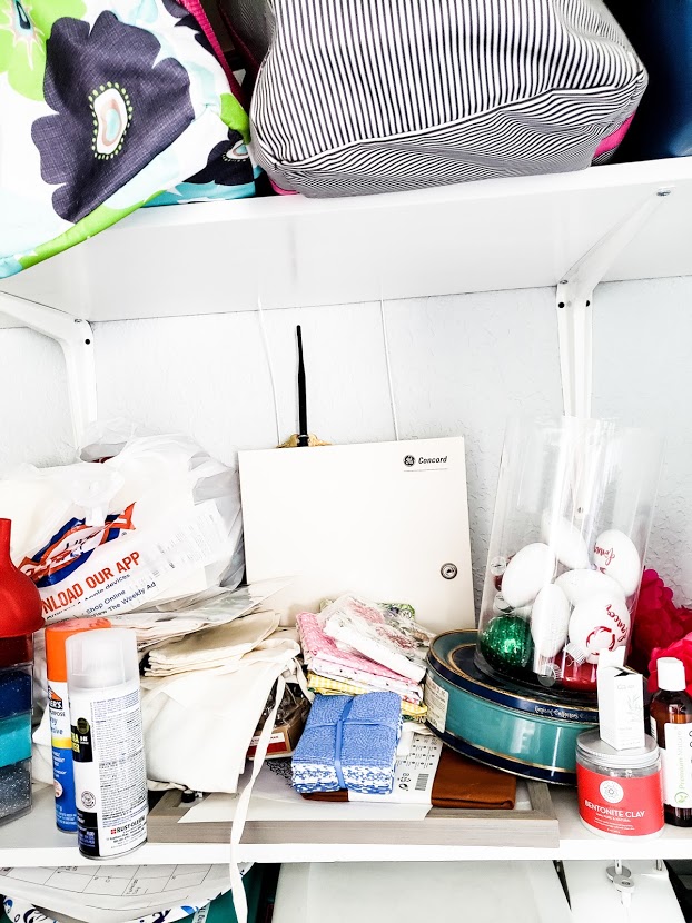 Messy-shelves-with craft-supplies-stacked-on-top-of-each-other-falling-to-the-floor