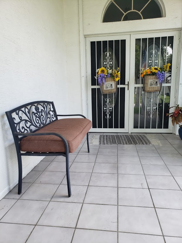 Bench on front porch with drab brown cushion cover