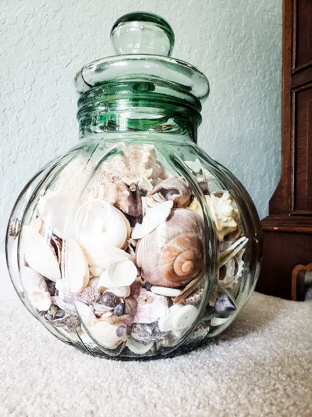 Green glass large decorative jar with lid filled wit seashells