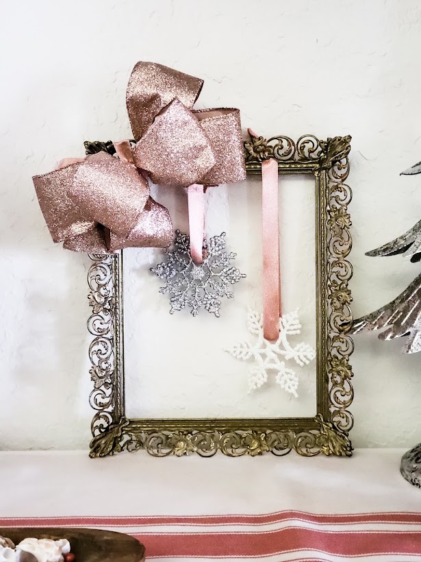 Finished picture frame wreath leaning up against a white wall.