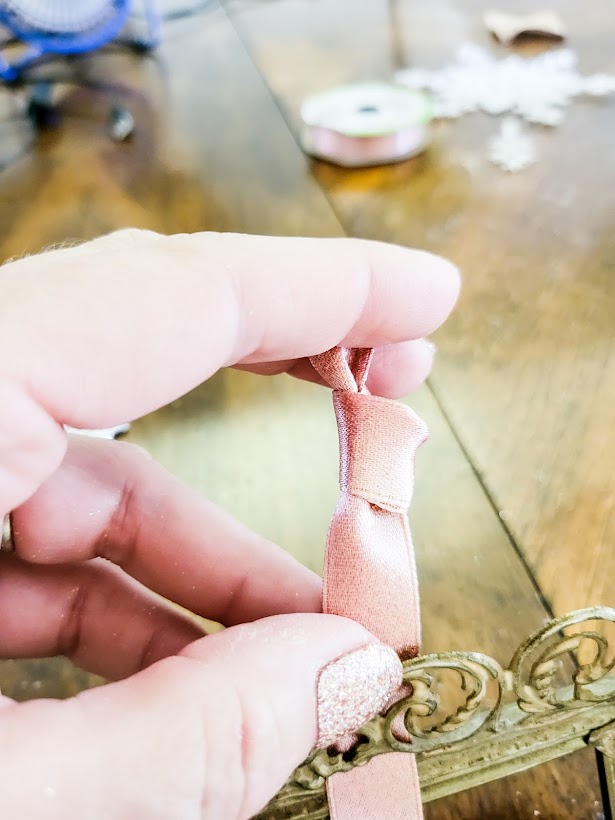 Tying both ends of the ribbon in a knot.