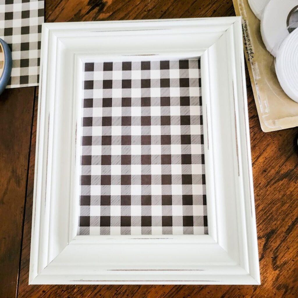 A picture containing the frame with the Buffalo check paper inside.