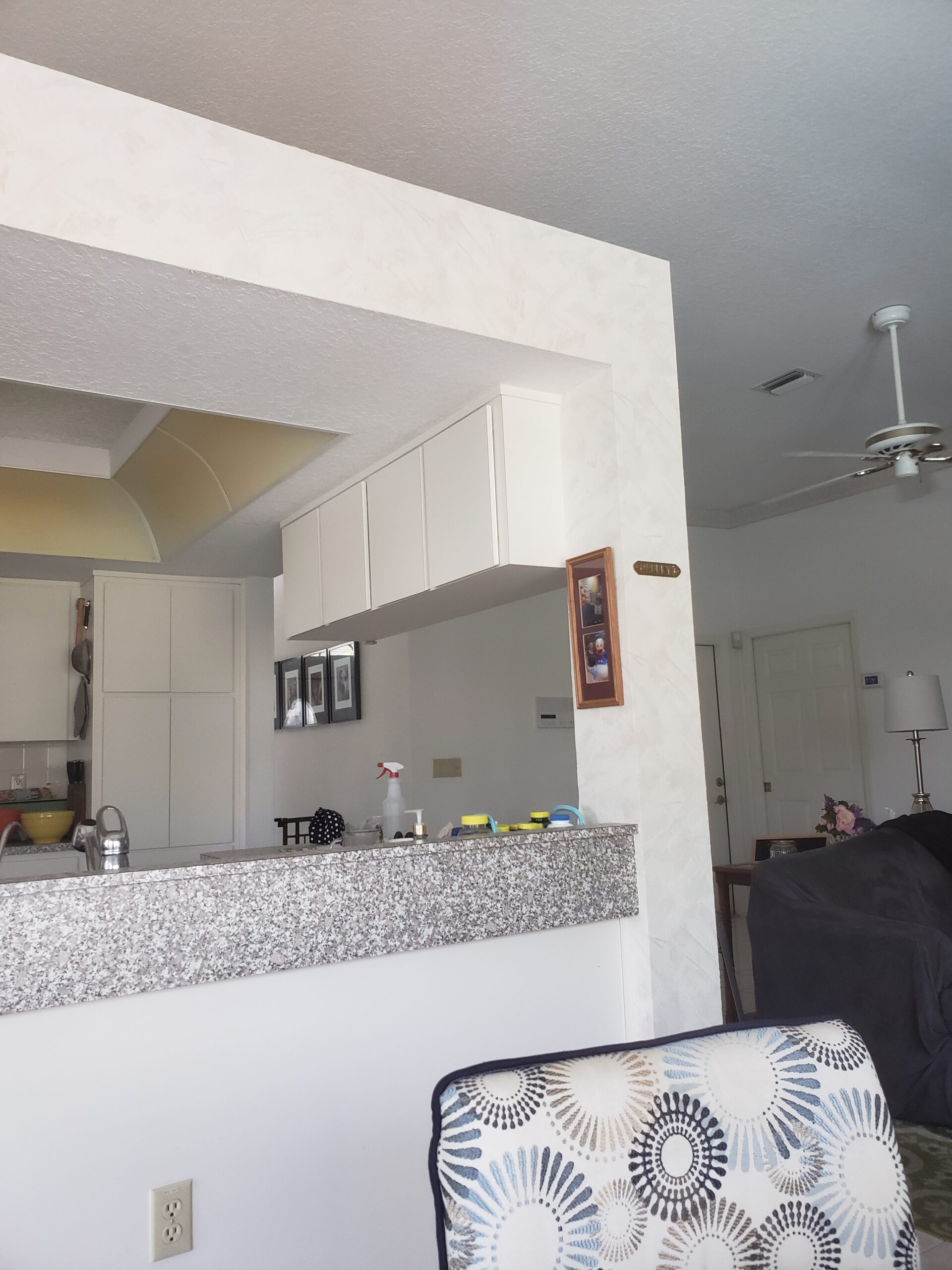 A picture of our kitchen island with post and piece of wall over the island.