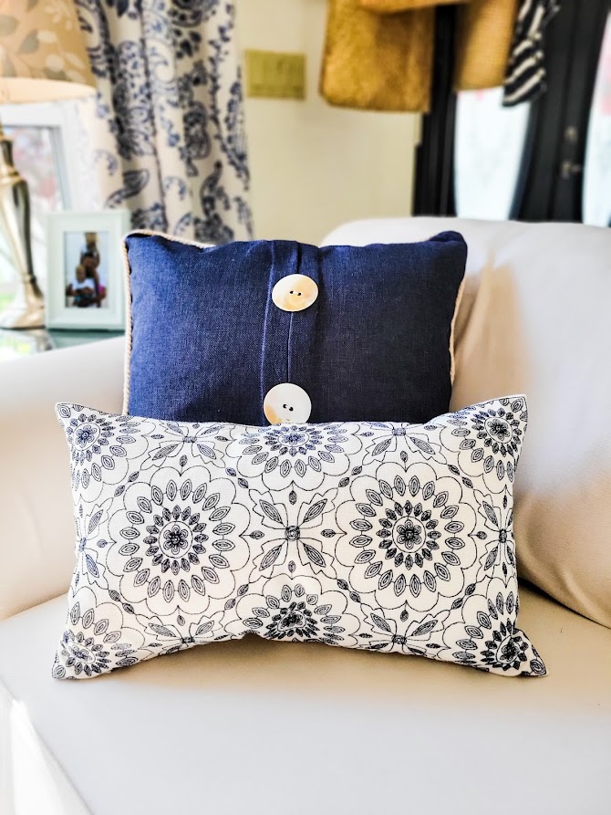 A picture of my navy and white throw pillows on my slipcovered sofa