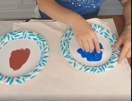 painting blue and red stars on a white pillow cover