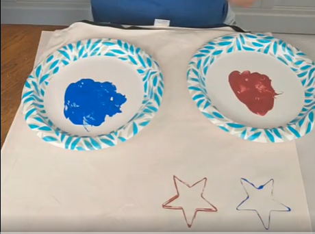 painting blue and red stars on a white pillow cover