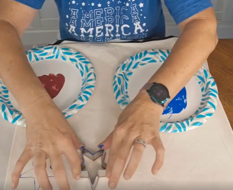 painting blue and red stars on a white pillow cover