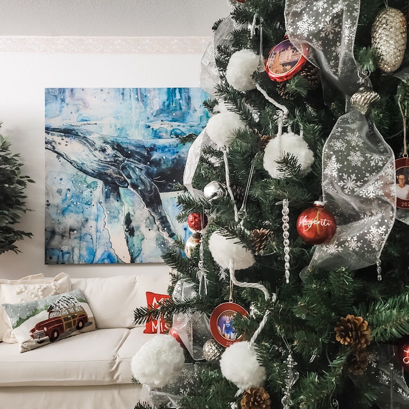 Christmas tree with large whale art on a wall