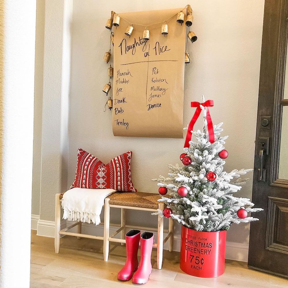 entryway with a mini Christmas tree and a naughty or nice poster on the wall