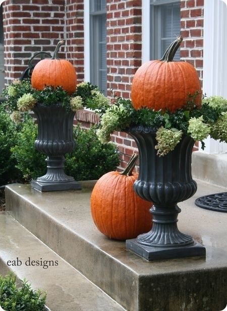 front stoop with black urns with pumpkins on top