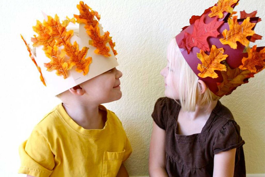 two children with construction paper leaf hats