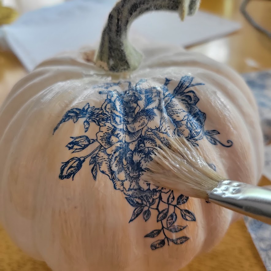 gluing napkins to a white pumpkin