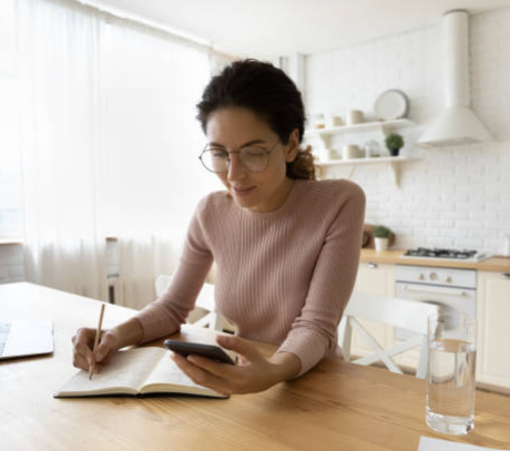 woman sitting at a table writing in a book