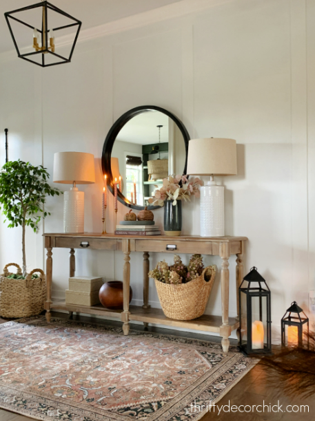 entryway with sofa table, lamps and a mirror