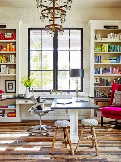 home office with large window and floor to ceiling bookshelves