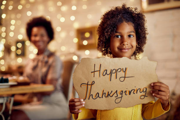 child holding a happy thanksgiving sign