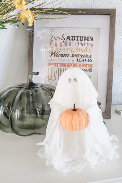 halloween cheesecloth ghost holding a tiny pumpkin