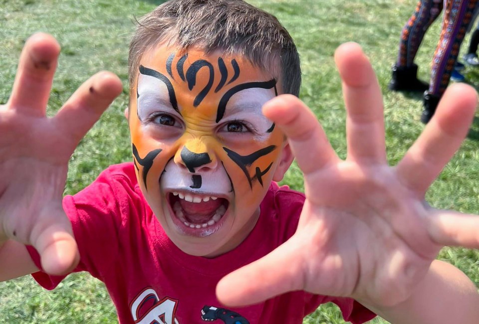 child's face painted as a tiger