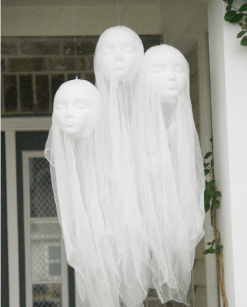 styrofoam mannequin heads covered in sheer fabric ghosts on front porch
