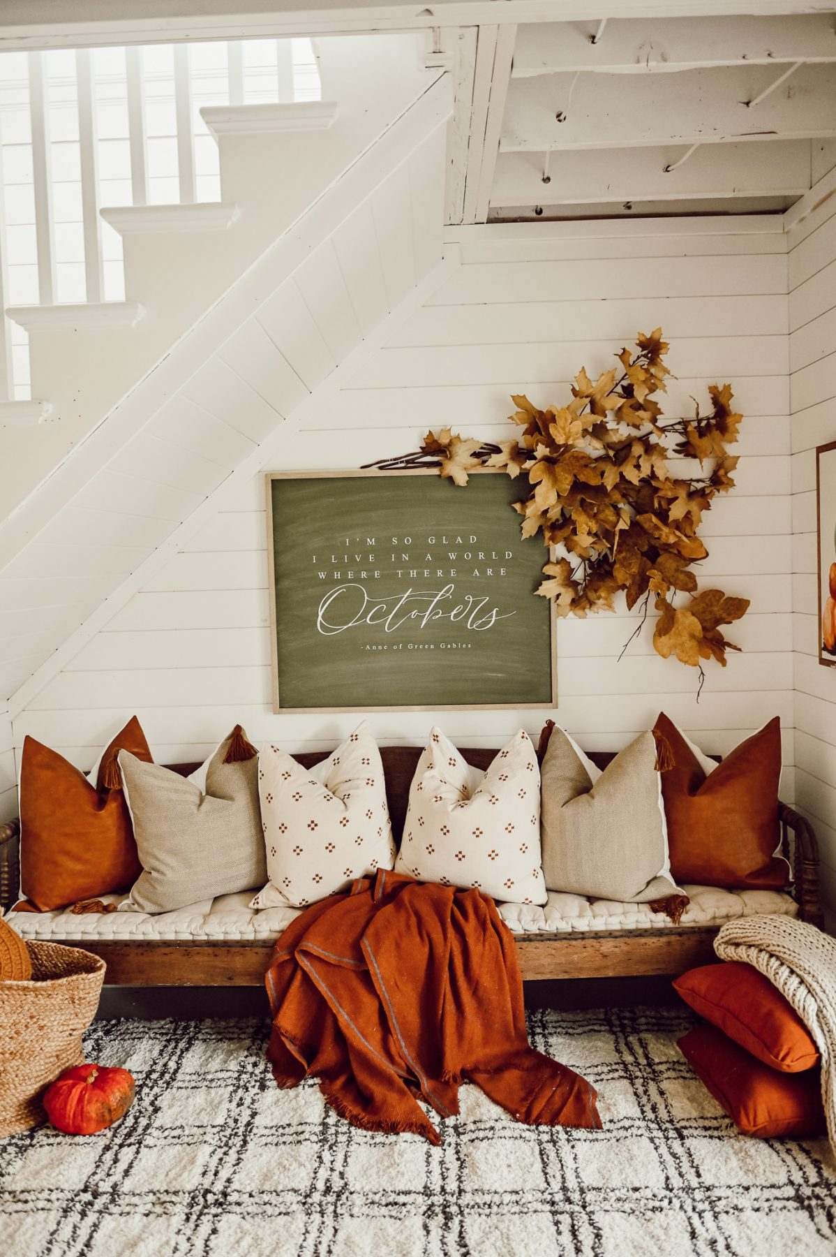 cozy nook under the stairs with fall pillows and blanket