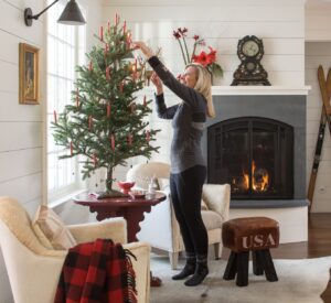 woman decorating a Christmas tree in her living room