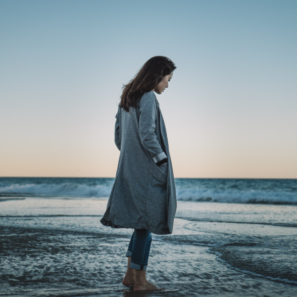 woman by the ocean in a winter coat