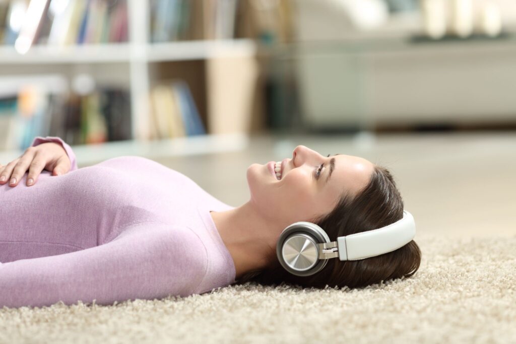 woman lying on the floor with headphones on 10 relaxing tips to reduce stress in your home