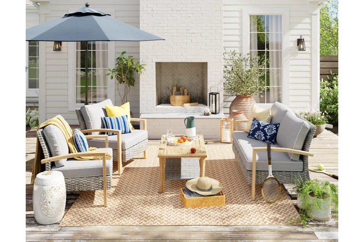 a patio with a fireplace, cushioned furniture, and an outdoor rug patio decor ideas