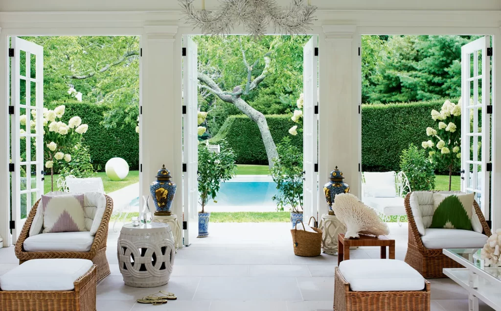 outdoor living area with big open doors and white walls infusing your home with summer vibes