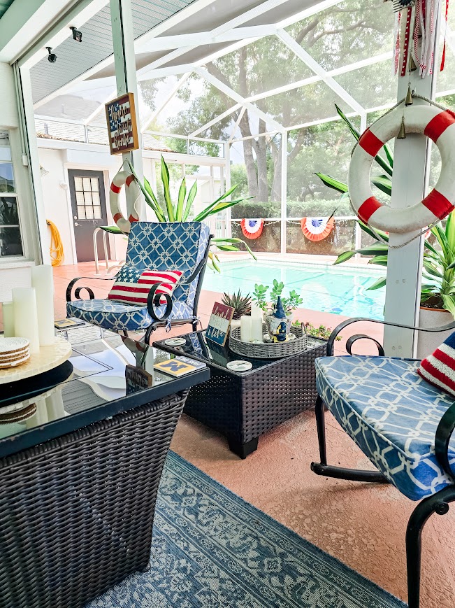 rocking chairs on a porch with a swimming pool and plants