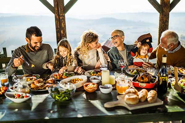 a group of people sitting at a table eating fall potluck table