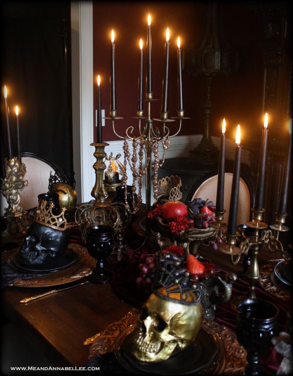 a spooky tablescape with silver candelabras, black candles and gold skulls