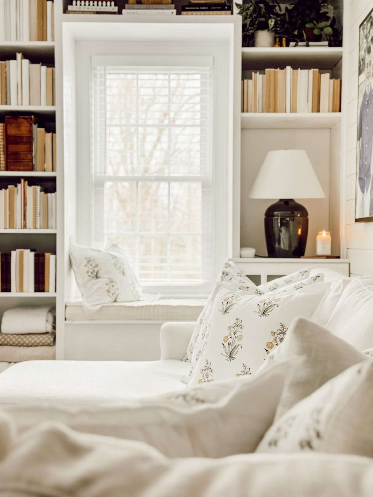 cozy white living room with a window and bookshelves and a white sofa