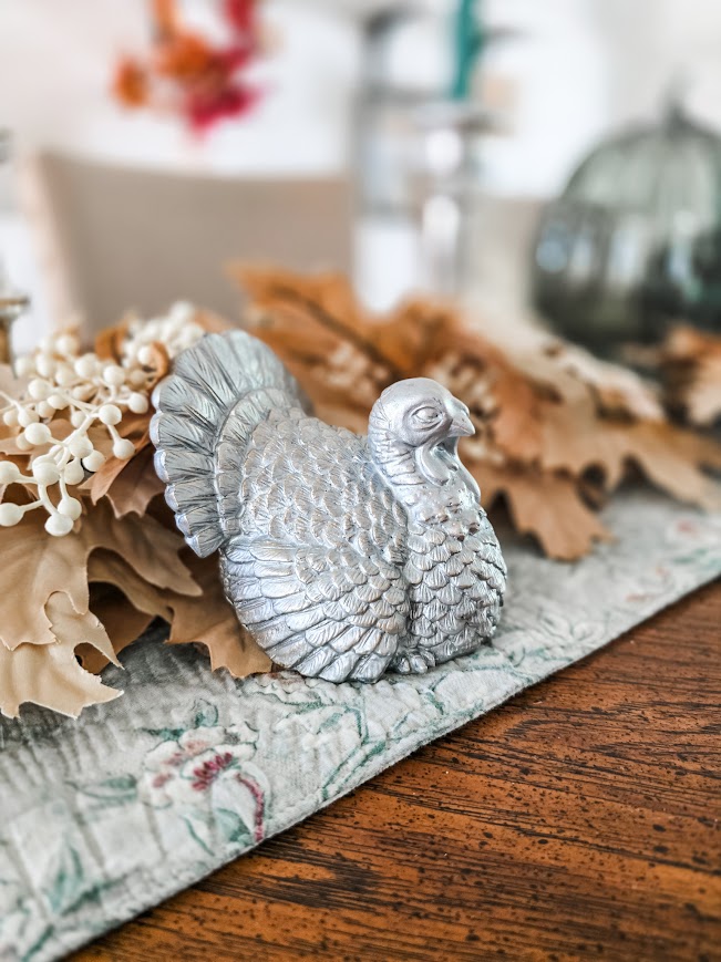 a thanksgiving holiday dining table with a silver turkey