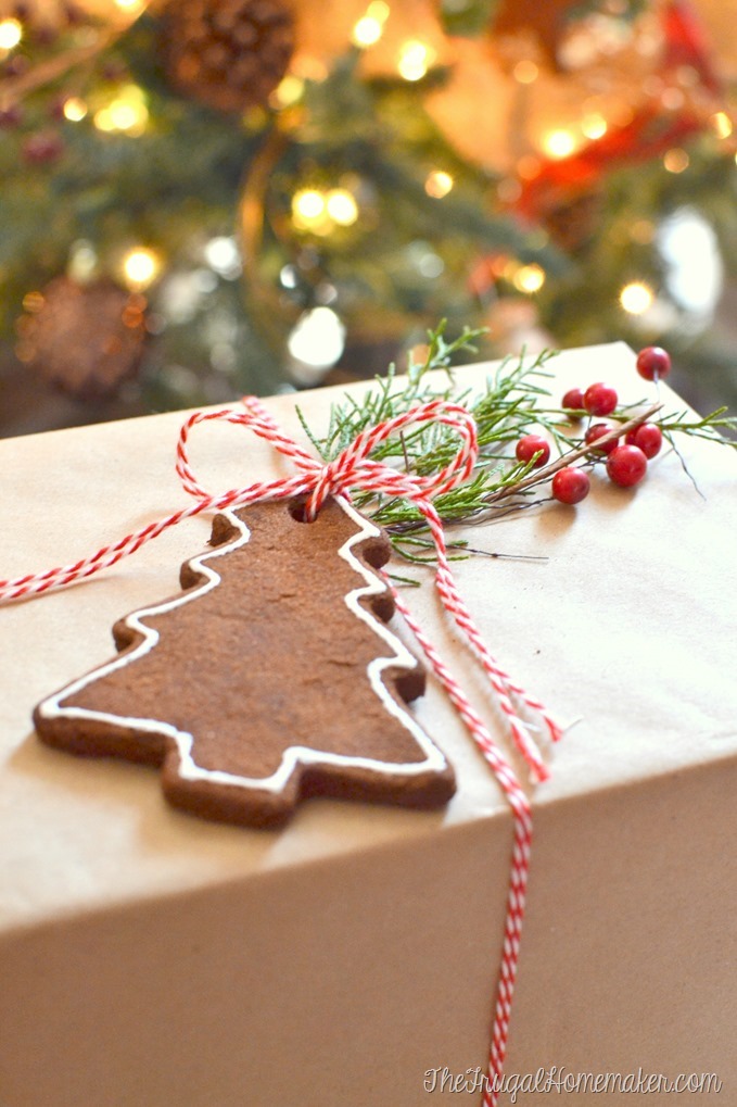 a package wrapped in brown paper with a cinnamon Christmas tree ornament on top