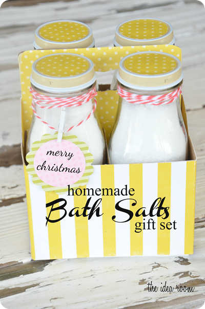 a yellow and white striped paper container holding 4 glass bottles of homemade bath salts frugal gift ideas