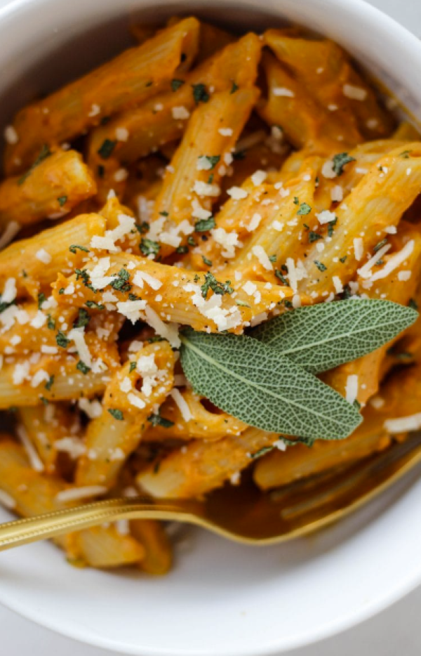 a closeup of pasts with pumpkin and sage sauce with 2 sage leaves on top great fall side dishes