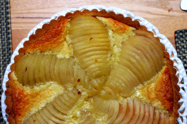 a pear and almond tart in a pan sitting on a table fabulous fall desserts