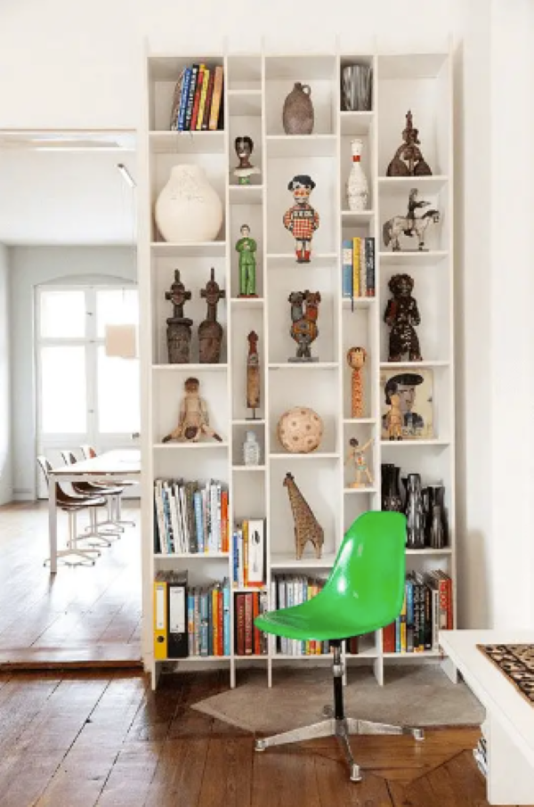 cozy home with white walls and a bookcase room divider with travel souvenirs' people with cozy homes know