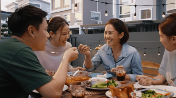 people laughing together and eating dinner at a table great conversation starters for your next party