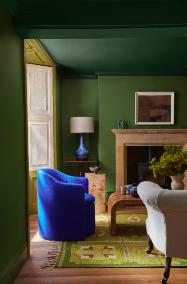 dark green living room walls and ceiling with a blue chair incorporate color drenching into your home