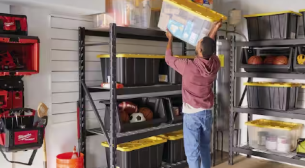 a man putting a storage bin on a high shelf daily habits for an organized home