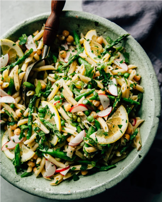 a bowl of vegetable pasta salad with a spoon church supper ideas for spring