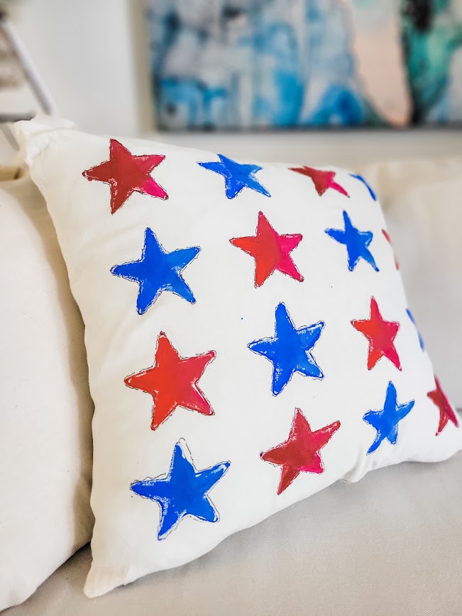 red, white, and blue stars on a white pillow cover