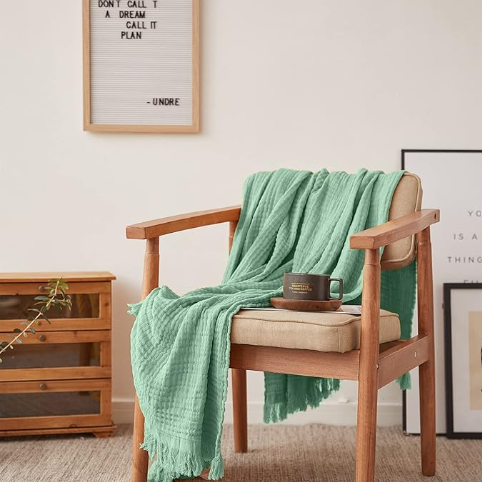 a green throw blanket draped over a wooden chair summer decorating for small spaces