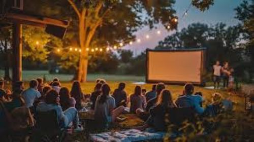 People sitting outside watching a movie on a projector screen
