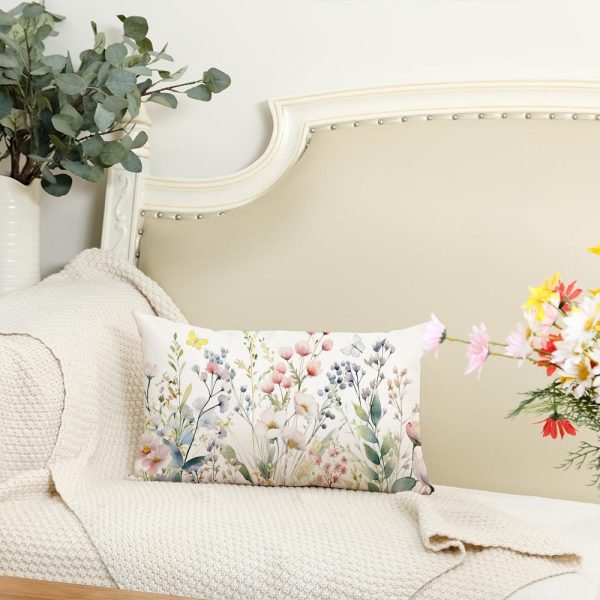 a floral patterned pillow on a white sofa