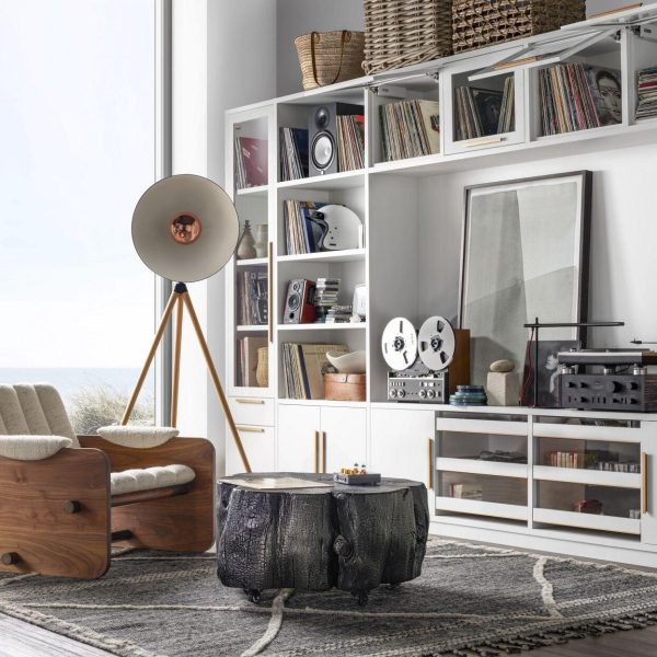 white living room with a brown chair, bookshelves and a large window home is more than a location