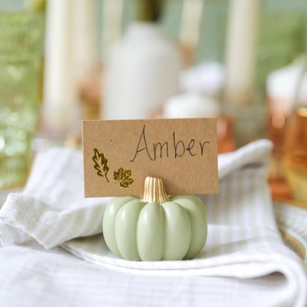 mini green pumpkin place card holder sitting on a white napkin